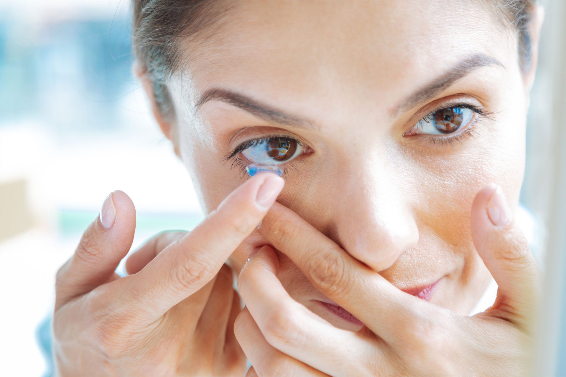 woman putting on contact lens | optometrist in nashville